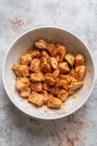 Toss chicken cubes with olive oil, paprika, garlic powder, salt, and pepper