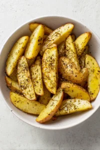 Toss potato wedges with truffle oil, salt, black pepper, and garlic powder