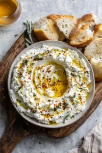 Transfer the whipped feta mixture onto a serving board, creating a small well in the center for hot honey
