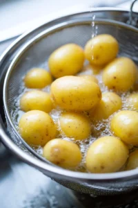Wash the baby potatoes and boil them in salted water until fork-tender