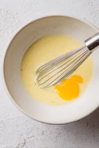 Whisk together eggs, milk, and vanilla extract in a medium bowl