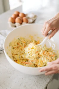 Whisk together eggs, salt, pepper, and cheese with pasta
