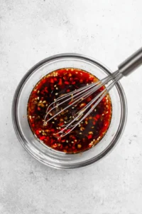 Whisk together the soy sauce, chili sauce, sesame oil, ginger, and garlic to create the sauce