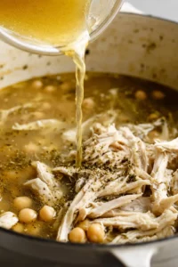 Add chicken broth, shredded chicken, chickpeas, oregano, salt, and pepper to the pot and bring to a gentle boil