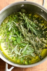 Add chopped fresh herbs to the cooled tallow mixture and stir well