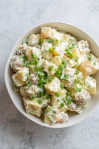 Add cooled potatoes and green onions to dressing and toss gently