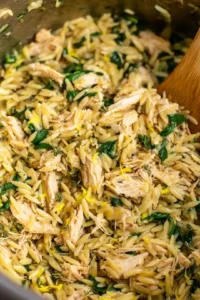 Add shredded chicken, lemon juice, zest, thyme, oregano, and spinach to cooked orzo