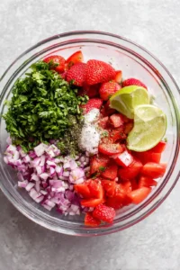 Add the finely chopped red onion, fresh cilantro, lime juice, salt, and black pepper to the bowl.