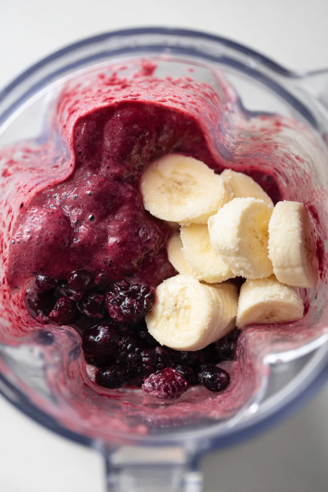 Blend frozen mixed berries, sliced banana, almond milk, and collagen powder until smooth
