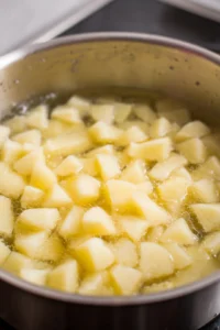 Boil diced potatoes in salted water until tender