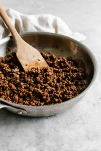 Brown the ground beef or cauliflower in a large skillet until fully cooked