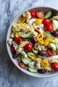 Combine cherry tomatoes, cucumber, bell pepper, kalamata olives, cooked pasta, and cooked chicken in a large bowl