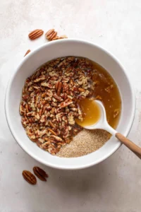 Combine chopped pecans, brown sugar, and corn syrup in a bowl until well blended