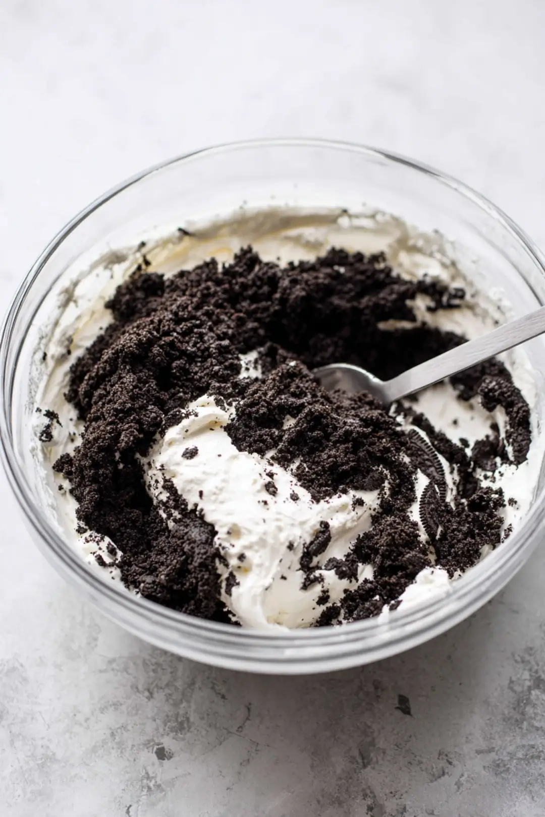 Combine crushed Oreo cookies and softened cream cheese in a mixing bowl
