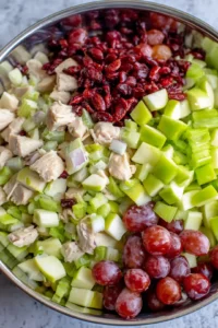 Combine diced chicken, diced apple, chopped celery, and halved grapes in a large bowl