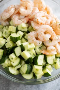 Combine diced cucumber and cooked shrimp in a large bowl