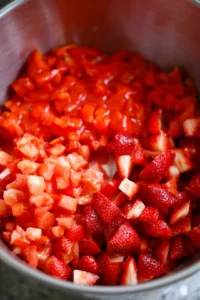Combine diced strawberries and tomatoes in a large mixing bowl