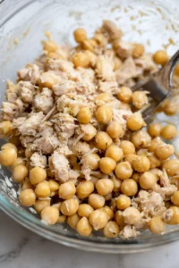 Combine drained canned tuna and chickpeas in a large mixing bowl