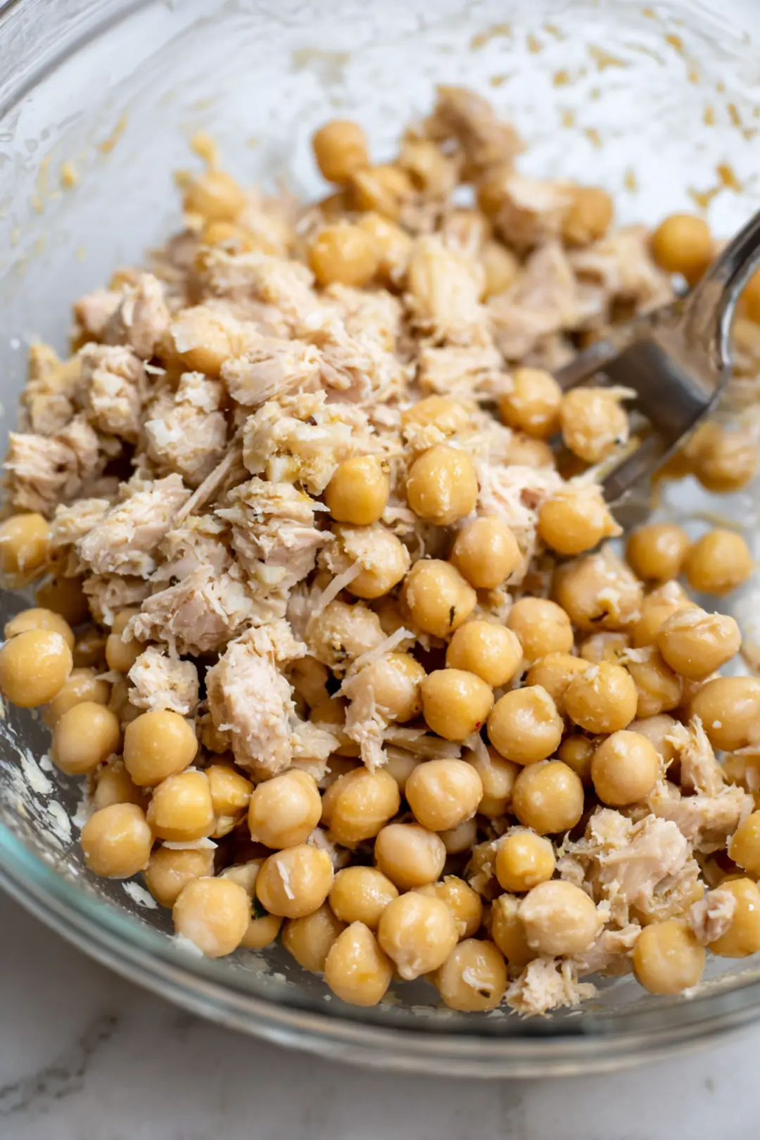 Combine drained canned tuna and chickpeas in a large mixing bowl