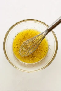 Combine dressing ingredients in a bowl and toss over salad