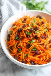 Combine grated carrots, raisins, and chopped parsley in a large bowl