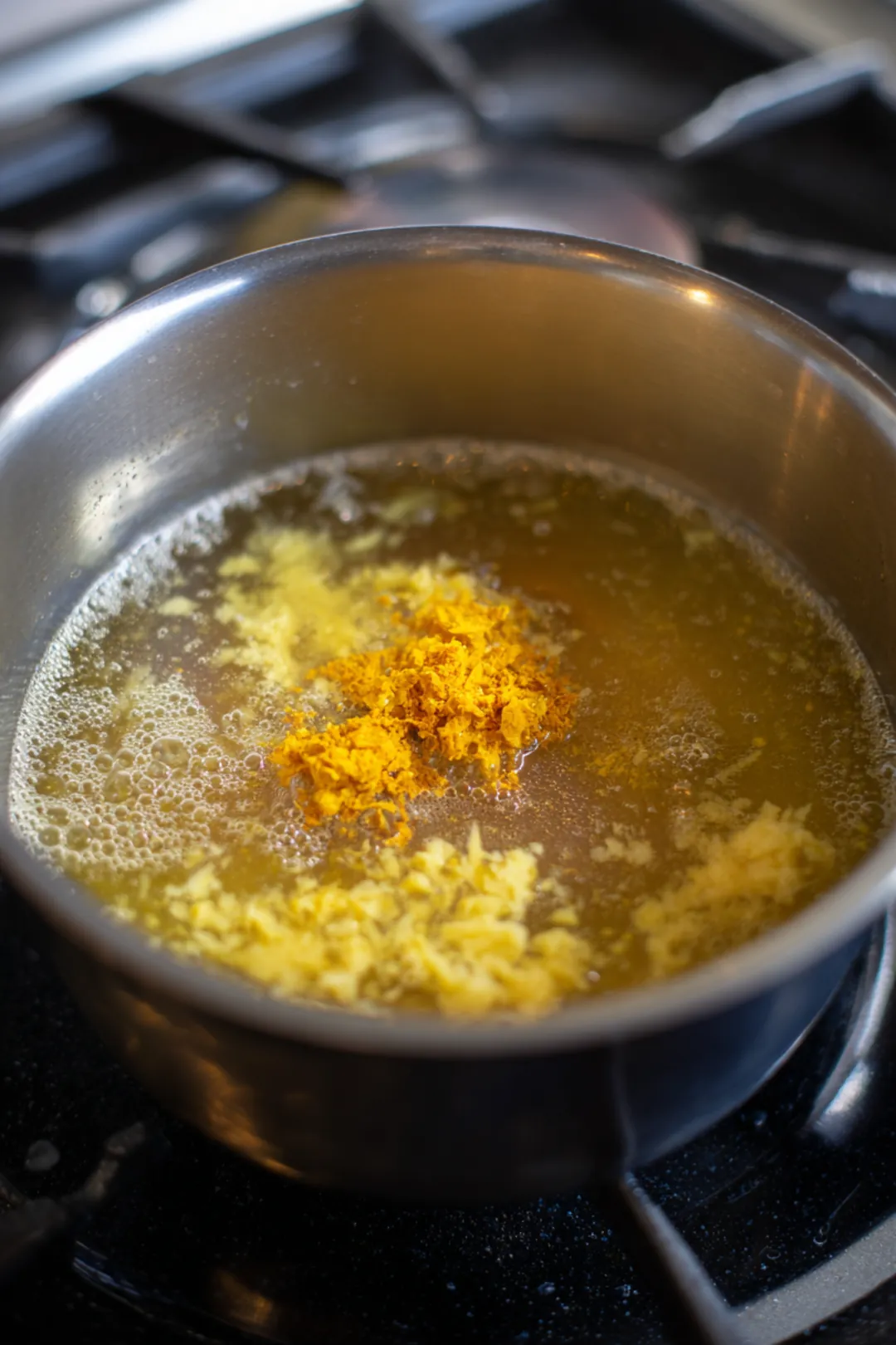 Combine lukewarm water, grated ginger, and grated turmeric in a pot