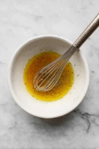Combine shredded cabbage and grated apples in a large mixing bowl