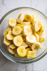 Combine sliced bananas, sugar, and lemon juice in a large mixing bowl