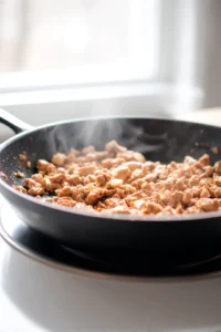 Cook the ground chicken in a large skillet until browned