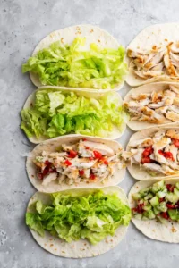 Distribute lettuce onto tortilla wraps