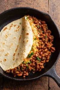 Heat a large skillet over medium heat and fill a tortilla with bean and cheese mixture