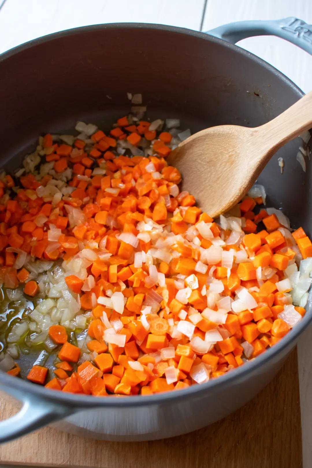 Heat olive oil in a large pot and sauté onion until translucent, then add garlic and carrots
