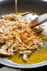 Heat olive oil in a skillet and add shredded chicken with taco seasoning