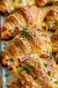 Layer the diced ham, turkey, and cheese over croissant pieces