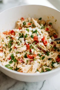 Mix shredded chicken with tomatoes, cilantro, and feta cheese