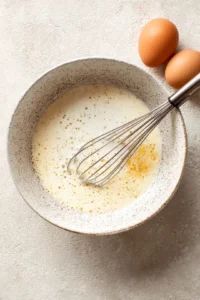 Pour egg mixture over layered ingredients and let it sit