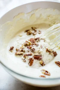 Pour the batter into the prepared loaf pan and smooth the top