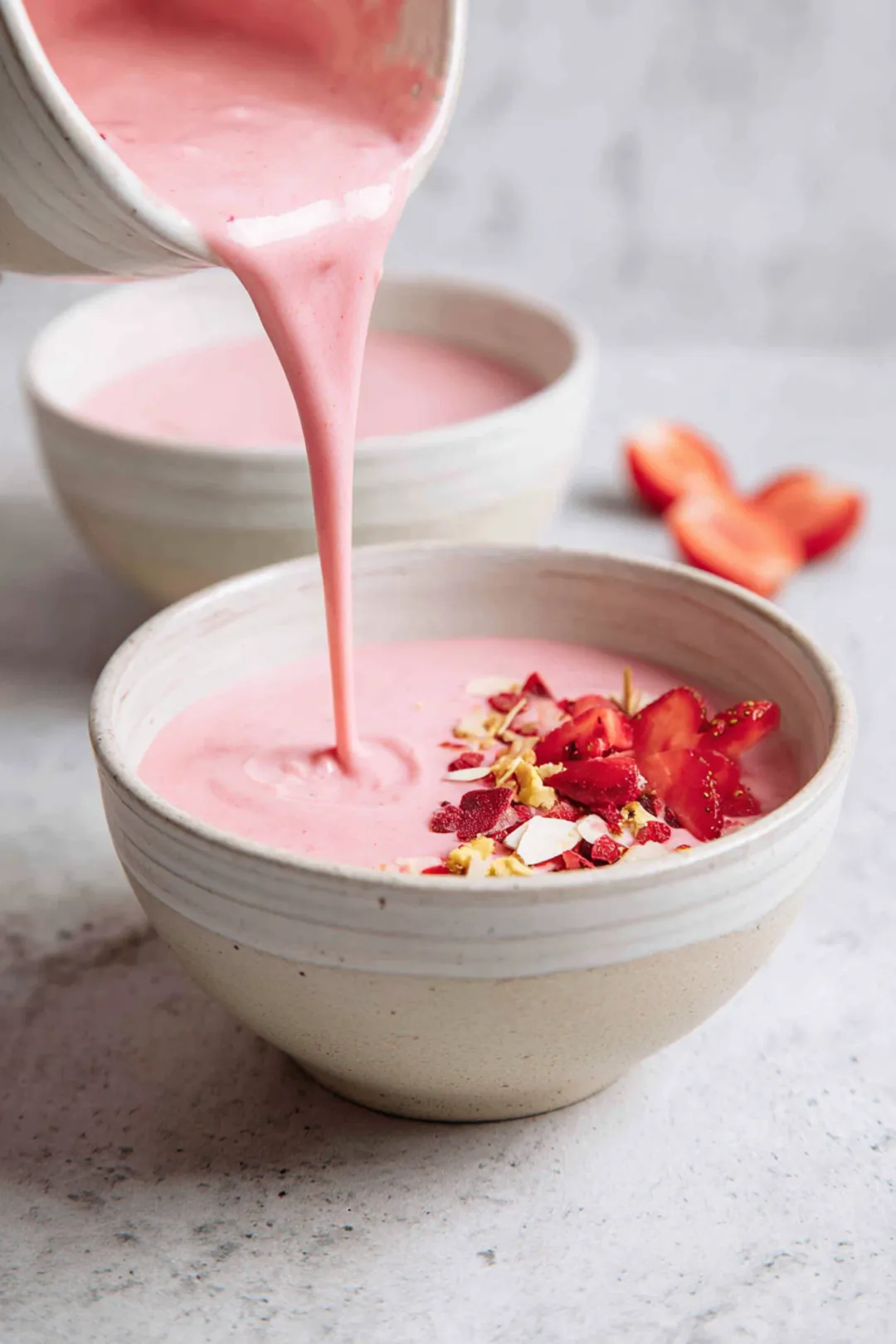 Pour the smoothie mixture into two bowls, creating a nice base for toppings.