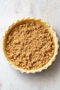 Press the crumb mixture firmly into the bottom and up the sides of a 9-inch pie dish to form the crust. Chill in the refrigerator for about 30 minutes to set.