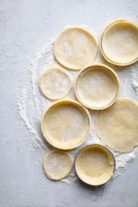 Roll out puff pastry sheets and cut into circles for tartlet pans