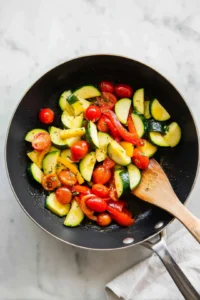 Sauté zucchini, bell pepper, and cherry tomatoes in olive oil until tender