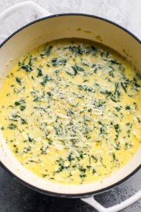 Stir in heavy cream, spinach, mozzarella, and parmesan cheese into the cooked noodles
