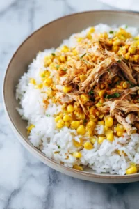 Top the rice with shredded chicken and street corn mixture, then add cilantro, avocado, and salsa