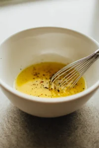 Whisk together olive oil, lemon juice, dijon mustard, salt, and pepper